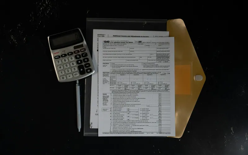 Calculadora sobre documentos organizados em uma pasta escura.